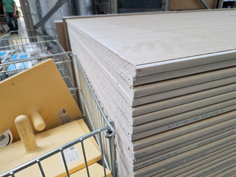 Gestapelte Gipsplatten mit sichtbaren Kanten auf einem Transportwagen